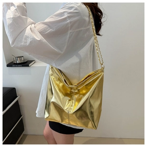 Detail view of the large gold tote bag with metallic sheen and elegant chain strap
