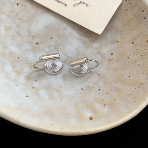 Close-up of silver geometric ear clip converters with comfortable clear silicone pads