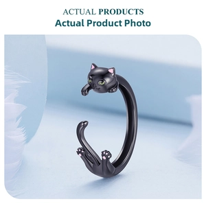 Macro detail of adjustable black cat silver ring with green stone eyes and pink ears