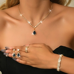 Detail view of pear-cut blue sapphire necklace and earrings set with sparkling zircons
