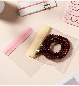 Transparent PVC storage bags with pink zip lock protecting red wooden bead bracelets