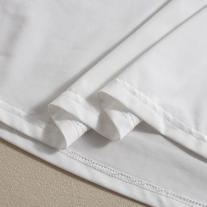 Detail of white mesh dress hem showing fine diagonal texture and double-stitch sewing