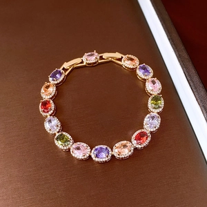 Macro shot of vintage gold bracelet featuring colorful oval zircon stones with halo details