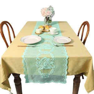 Mint green lace table runner with hollow floral patterns and mustard yellow tablecloth