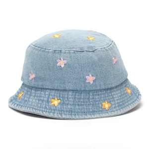 Detailed close-up of purple and yellow flower embroidery on light blue denim bucket hat