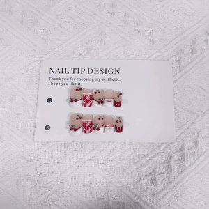 Handmade Christmas press-on nails with 3D bows, cherry patterns, and red plaid designs
