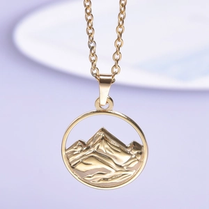 Detailed close-up of a 18K gold stainless steel mountain pendant with a round frame