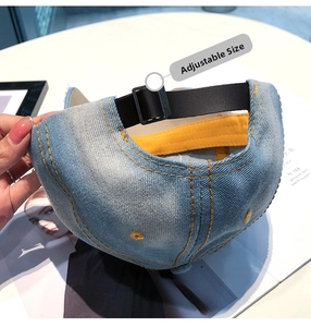 Detailsicht auf verstellbaren Lederriemen und Schnalle an einer blauen Denim-Kappe