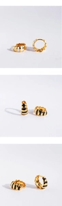 Detailansichten goldener Croissant-Ohrringe mit schwarz-weiß gestreiftem Emaille-Muster