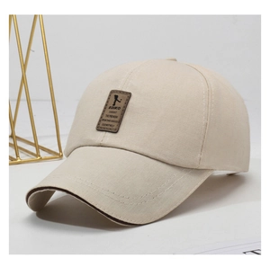 Close-up of beige canvas baseball cap featuring contrast brim and leather logo patch