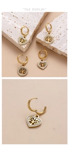 Close-up of gold stainless steel earrings with hollow Tree of Life heart and round charms