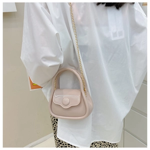 Macro detail of beige jelly mini bag showing metal chain strap and glossy texture