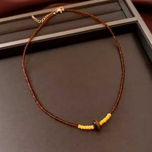 Détail du collier de perles avec pierre œil de tigre et fermoir mousqueton doré
