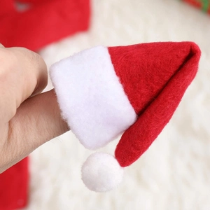 Miniature red knit Christmas hat with white pompom shown on a finger for scale