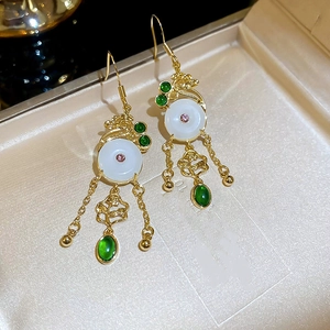 Close-up of Chinese style drop earrings with white jade buckle and green teardrop stone