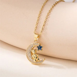 Macro shot of gold teddy bear on crescent moon pendant with blue star and zircon details