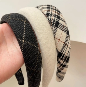 Close-up of vintage plaid and solid beige knit headbands for a classic preppy style