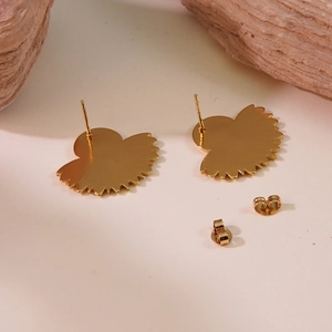 Detailed view of vintage gold fan-shaped earrings with butterfly backings on stone décor
