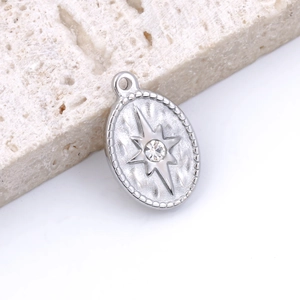 Macro view of silver oval star pendant with embedded rhinestone on porous stone base