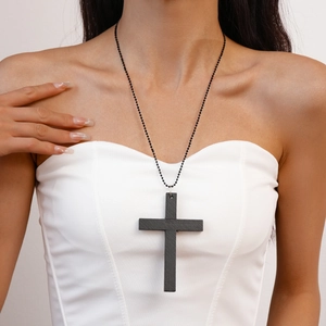 Détail du pendentif croix en bois sombre avec chaîne à billes noire sur modèle