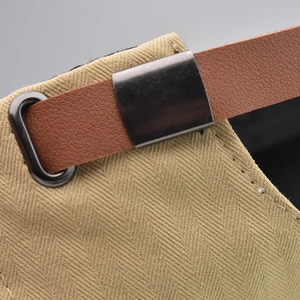 Detail of adjustable brown leather strap and metal buckle on breathable newsboy cap