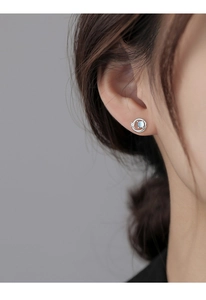 Detail view of silver Saturn stud earrings with blue glass stone and mini star accent