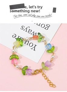 Detailed close-up of a colorful gradient tulip petal bead bracelet with white pearls