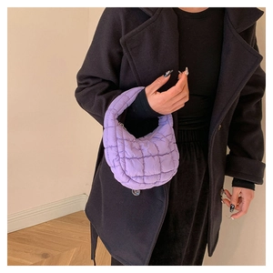 Detail of purple quilted puffer mini bag showing soft texture and padded fabric