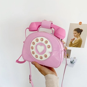 Macro detail of glossy pink patent leather crossbody bag with creative telephone dial design