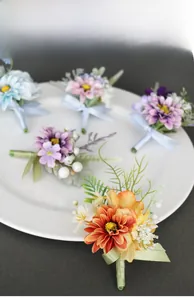 Detailed view of handmade artificial daisy corsages with ribbons on white display plate