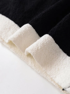 Close-up of the contrasting black and white knit fabric texture and fine stitching detail