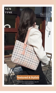 Detail of pink leather straps and plaid pattern on a stylish large capacity tote bag