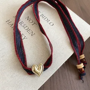 Denim fabric heart pendant necklace with striped knit ribbon and gold heart detail