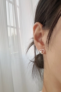 Close-up of a 925 sterling silver hollow heart earring with a round freshwater pearl