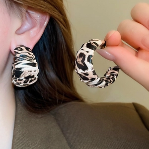 Détail de créoles en C à motif léopard pour un look vintage d'automne élégant