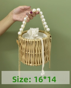 Detail view of a handmade woven bucket bag with pearl handle and metal chain straps