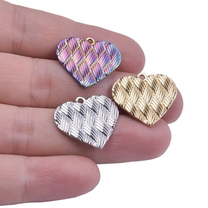 Detailed view of heart-shaped pendants with woven texture in gold, silver, and rainbow colors
