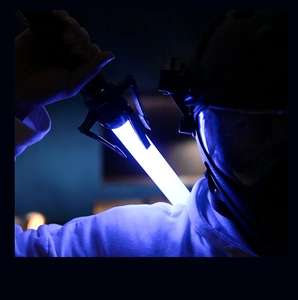 Close-up of cinematic blue glowing lightsaber held by a person in a tactical helmet