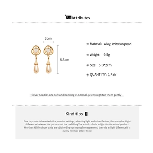 Detail view of heart-shaped pearl drop earrings showing size dimensions and materials