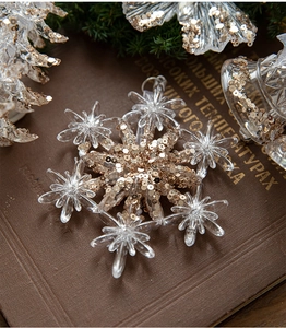 Macro shot of clear acrylic snowflake ornament with sparkling champagne gold sequins for Christmas