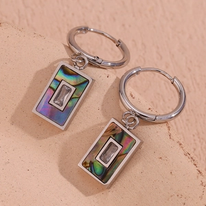 Macro shot of silver rectangle earrings with colorful abalone shell and clear zircon inlay