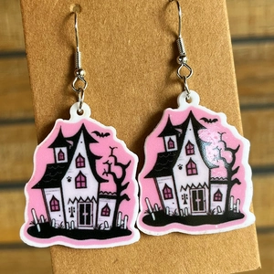 Detail of cute Halloween haunted house earrings in pink and black acrylic on cardboard