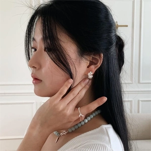 Minimalist silver heart studs and beaded necklace on a model with elegant profile view
