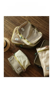 Macro detail of breathable mesh travel organizers with Free Travel label and zipper
