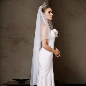 Detail of single-layer waist length white bridal veil in soft lightweight tulle fabric