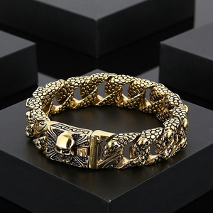 Detailed macro shot of gold skull bracelet with snake scale texture on dark background