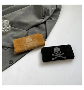 Close-up of brown and black suede wallets with rhinestone skull pattern on grey suit