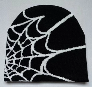Close-up of black knitted beanie featuring white spider web jacquard texture and fine stitching