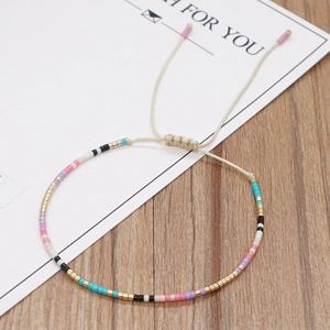 Bracciale bohémien fatto a mano con perline colorate e cordino regolabile su carta