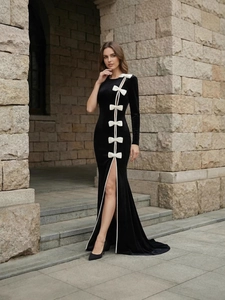 Elegant black velvet one-shoulder evening gown with white bows and high slit detail